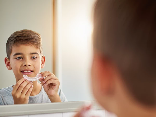 A boy with retainers after removing braces